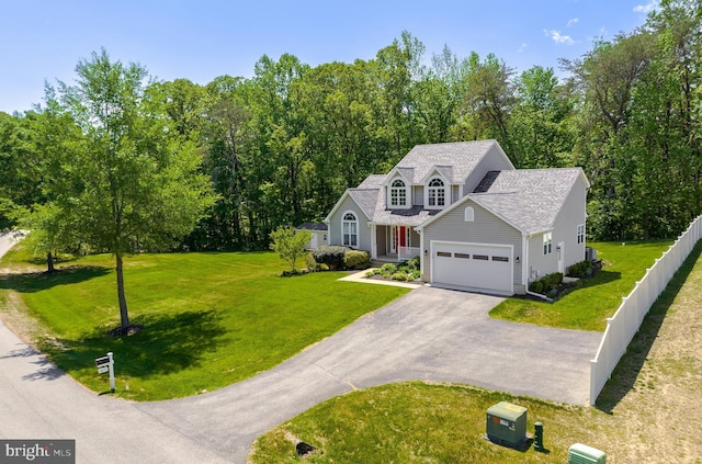 view of front of home with a front lawn, aphalt driveway, a garage, and fence