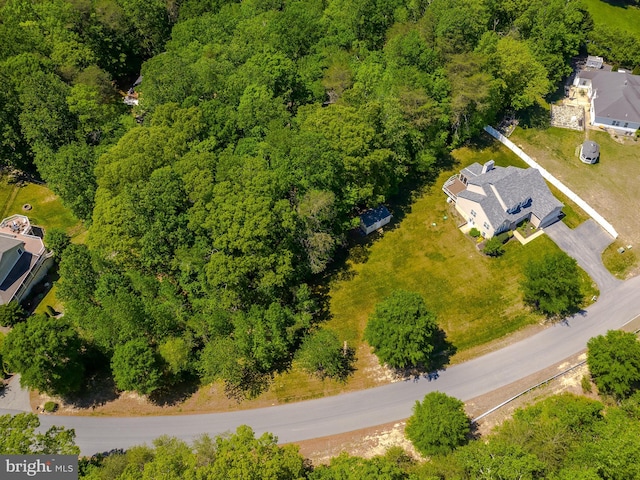 drone / aerial view featuring a wooded view
