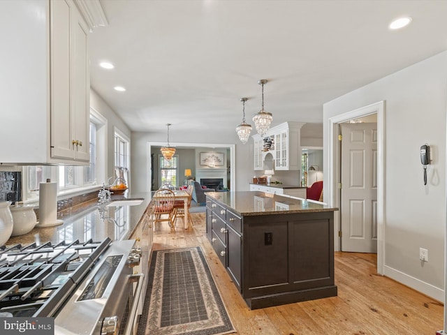744 Goose Neck Dr, Lititz, PA 17543 - kitchen with white cabinets, light wood-style floors, dark stone counters, dark brown cabinets, and pendant lighting