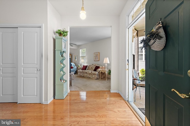 foyer entrance featuring light wood finished floors and baseboards