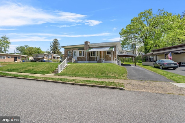 view of front of property featuring a front yard and a carport