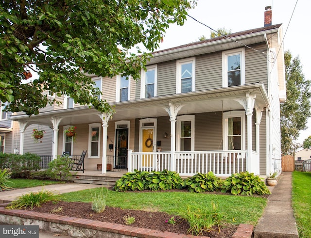 view of front of home featuring a porch and a chimney