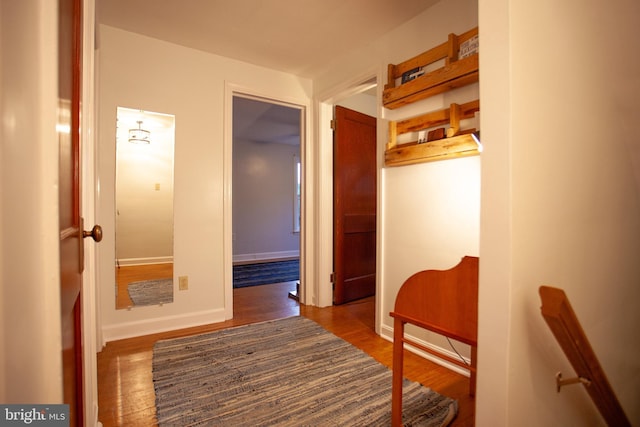 hallway with baseboards and wood finished floors