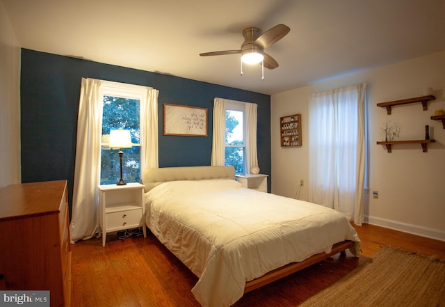 bedroom with baseboards, wood finished floors, and a ceiling fan