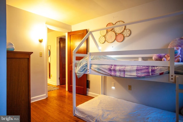 bedroom with baseboards and wood finished floors