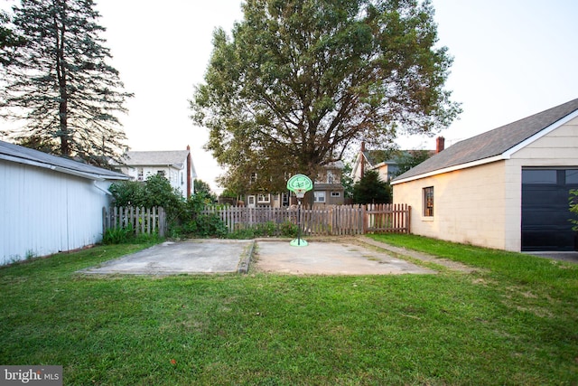 view of yard with an outbuilding, a patio, and fence