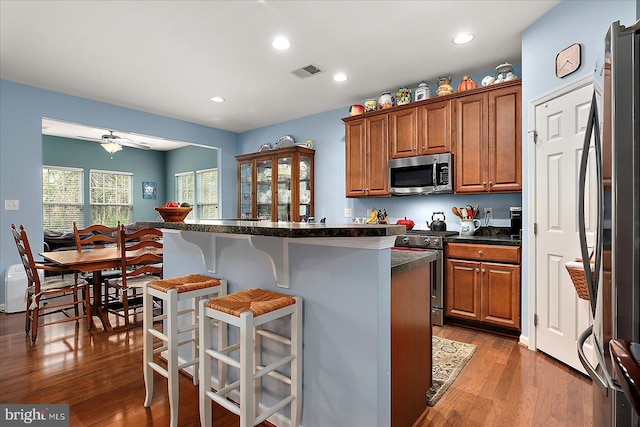 176 Bobbys Branch Rd Unit 56, Millsboro, DE 19966 - kitchen featuring stainless steel appliances, a breakfast bar, brown cabinetry, light wood-style flooring, and recessed lighting