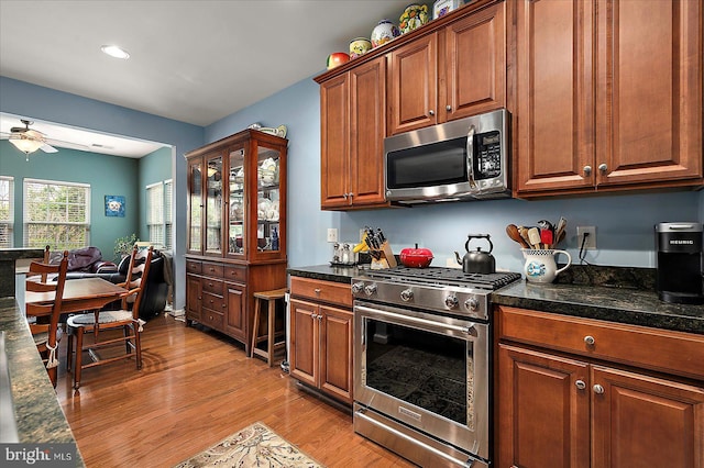 176 Bobbys Branch Rd Unit 56, Millsboro, DE 19966 - kitchen featuring appliances with stainless steel finishes, light wood-type flooring, dark countertops, ceiling fan, and brown cabinets