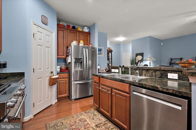 176 Bobbys Branch Rd Unit 56, Millsboro, DE 19966 - kitchen with appliances with stainless steel finishes, a sink, wood finished floors, dark countertops, and brown cabinetry