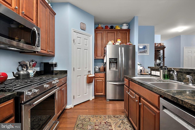 176 Bobbys Branch Rd Unit 56, Millsboro, DE 19966 - kitchen with stainless steel appliances, a sink, wood finished floors, and dark countertops