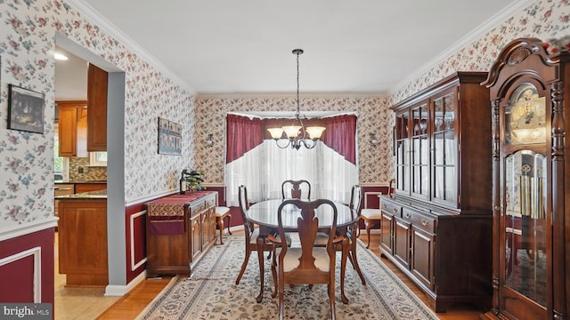 2707 Maynard Rd, Crofton, MD 21114 - dining area featuring a chandelier, wallpapered walls, ornamental molding, light wood-style flooring, and a wainscoted wall