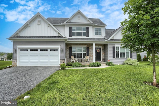 44 Danbury Dr, Mechanicsburg, PA 17050 - view of front of house featuring board and batten siding, a porch, asphalt driveway, stone siding, and a front lawn