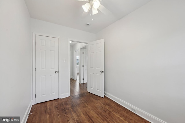 unfurnished bedroom with baseboards, dark wood-style floors, and ceiling fan