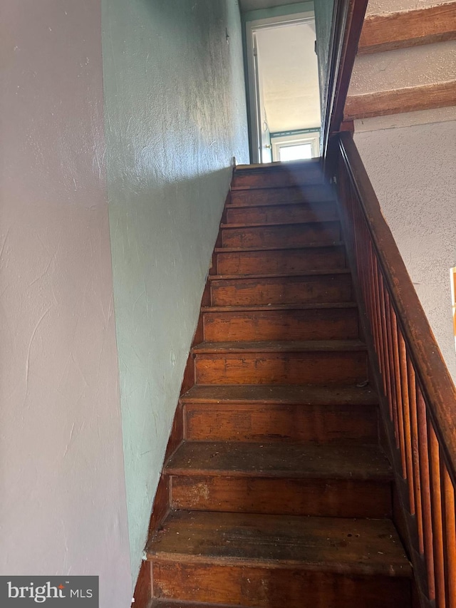 stairway featuring a textured wall