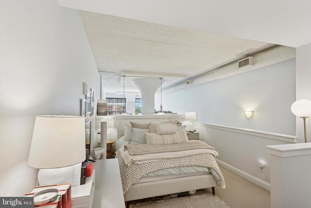 bedroom with carpet floors, baseboards, and a textured ceiling