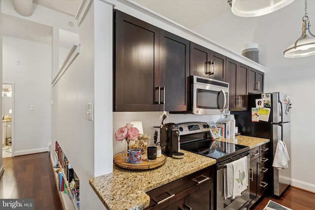 kitchen featuring appliances with stainless steel finishes, dark brown cabinets, dark wood finished floors, light stone counters, and baseboards