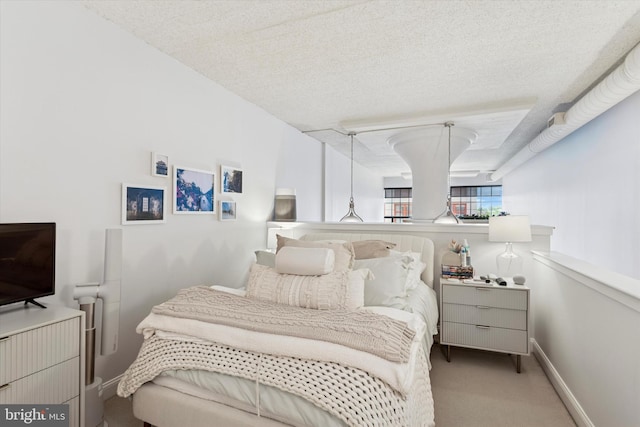 carpeted bedroom featuring a textured ceiling and baseboards