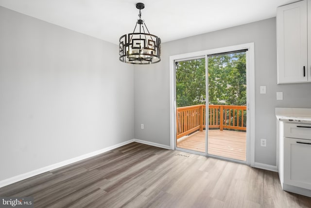 3104 Dynasty Dr, District Heights, MD 20747 - unfurnished dining area featuring light wood finished floors, a chandelier, and baseboards