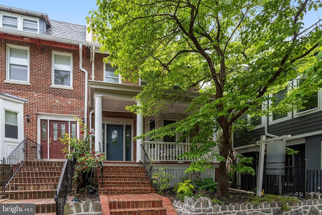 1326 Otis Pl NW, Washington, DC 20010 - townhome / multi-family property with brick siding, a porch, and mansard roof