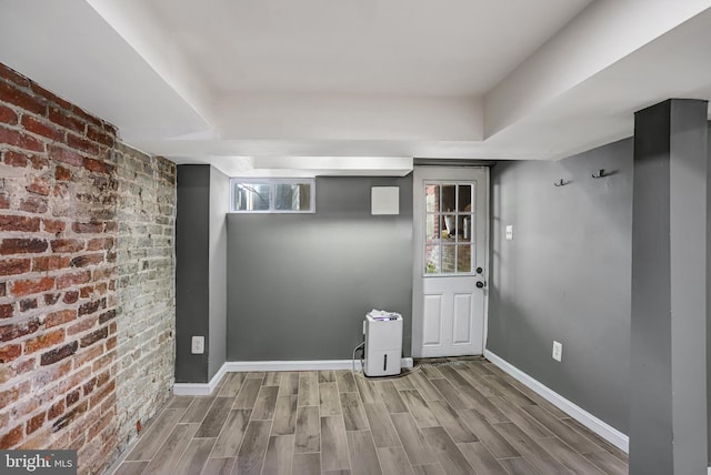 1326 Otis Pl NW, Washington, DC 20010 - below grade area with wood tiled floors, brick wall, and baseboards