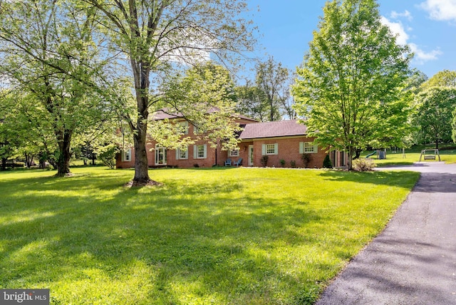 view of front of home with a front yard and brick siding