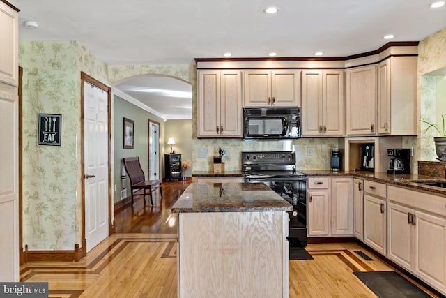 kitchen with black appliances, baseboards, arched walkways, light wood-type flooring, and a center island