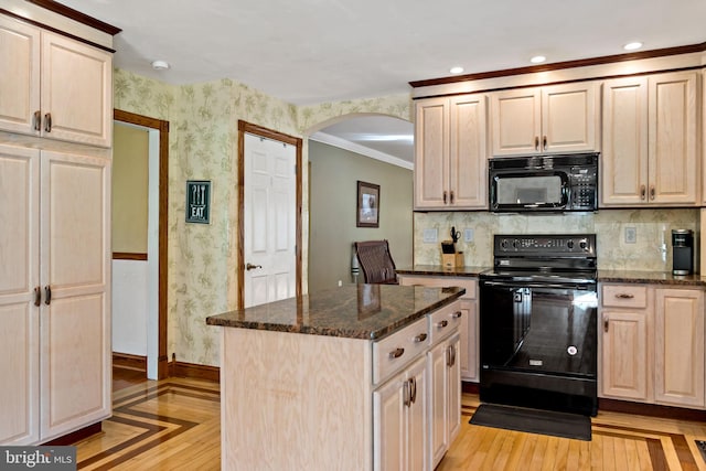 kitchen featuring black appliances, arched walkways, baseboards, wallpapered walls, and dark stone countertops