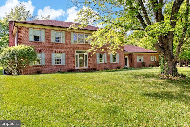 view of front of home with brick siding and a front lawn