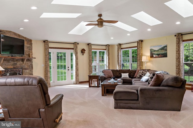 living room with a skylight, light carpet, and recessed lighting