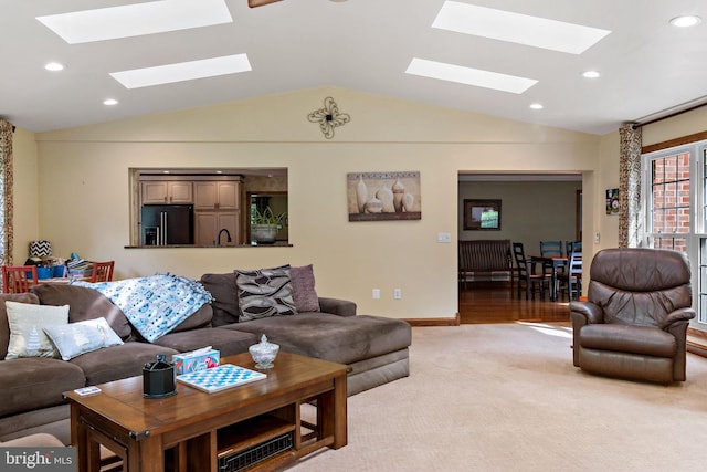 living room featuring a skylight, vaulted ceiling, light colored carpet, baseboards, and recessed lighting