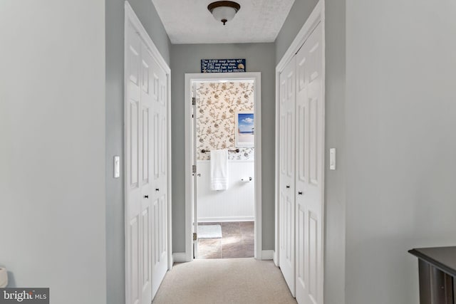 hallway with carpet and baseboards