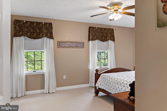 bedroom with carpet floors, baseboards, a textured ceiling, and a ceiling fan