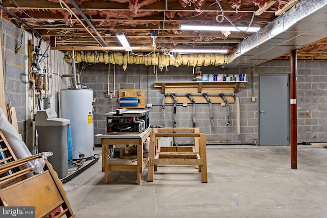 unfinished basement with water heater, a water softener system, a workshop area, and concrete block wall