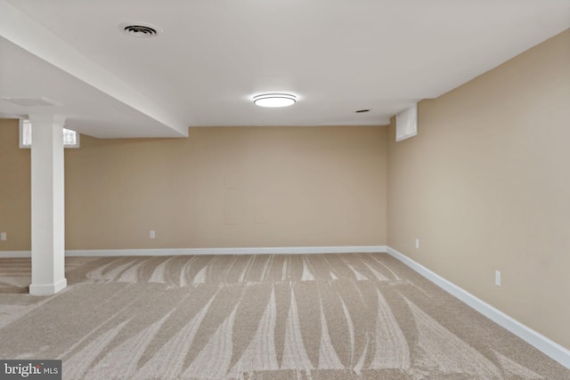 finished basement featuring baseboards and light carpet