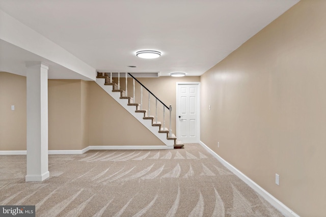 finished below grade area with carpet, baseboards, and stairs