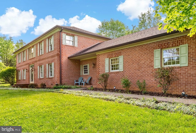 view of front of house with brick siding and a front yard