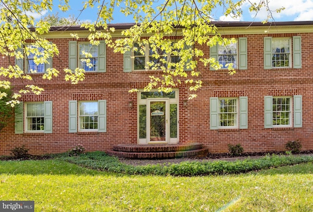 view of front of property featuring a front yard and brick siding