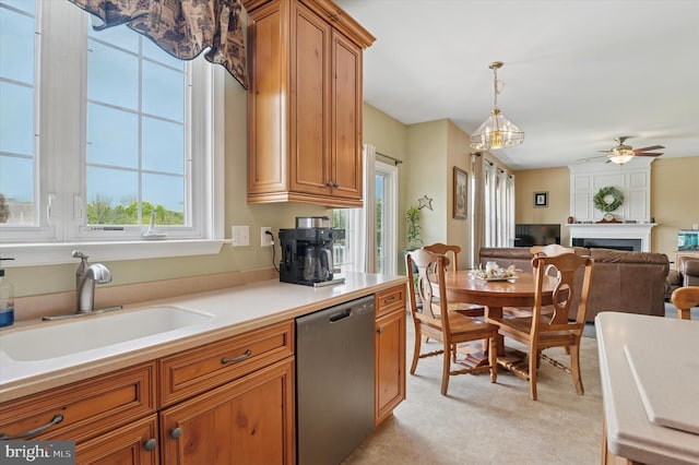 kitchen with dishwasher, a sink, brown cabinets, a ceiling fan, and open floor plan