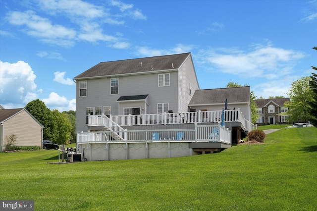 rear view of house featuring a wooden deck and a yard