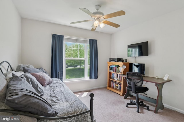 carpeted bedroom featuring baseboards, an office area, and a ceiling fan