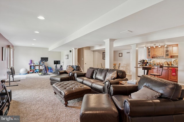 living room with ornate columns, wet bar, light colored carpet, and recessed lighting