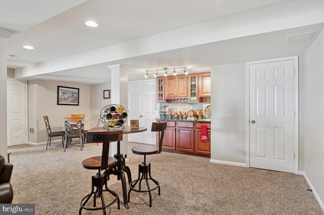 dining area featuring light colored carpet, bar, baseboards, and recessed lighting