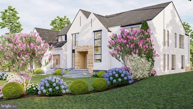 view of front of house featuring a front lawn, a shingled roof, stucco siding, and stone siding