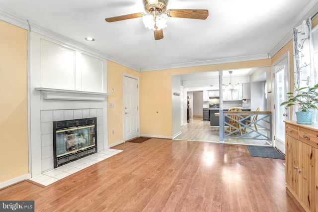 2158 Sebastian Rd, Fredericksburg, VA 22405 - unfurnished living room with a tile fireplace, ceiling fan, light wood-type flooring, baseboards, and crown molding