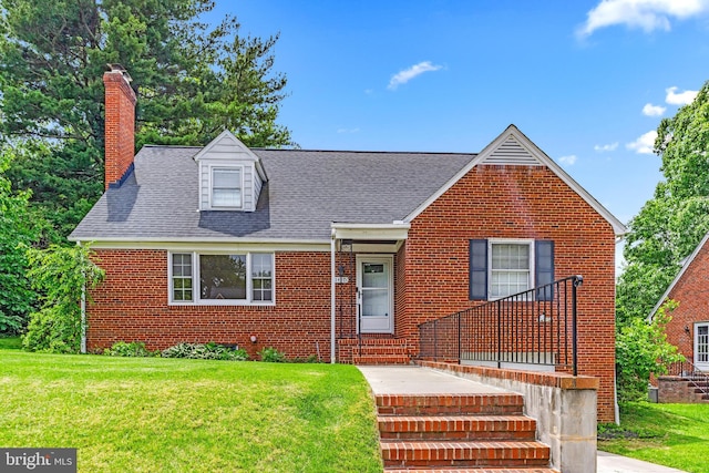 1417 Glendale Rd, Baltimore, MD 21239 - view of front of home with brick siding, a front yard, a chimney, and a shingled roof