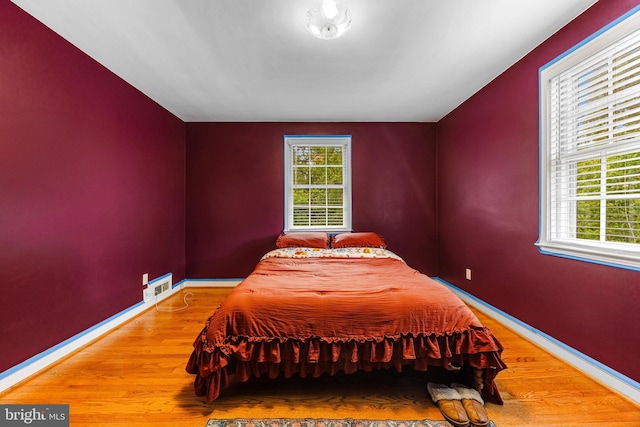 1417 Glendale Rd, Baltimore, MD 21239 - bedroom with multiple windows, wood finished floors, and baseboards