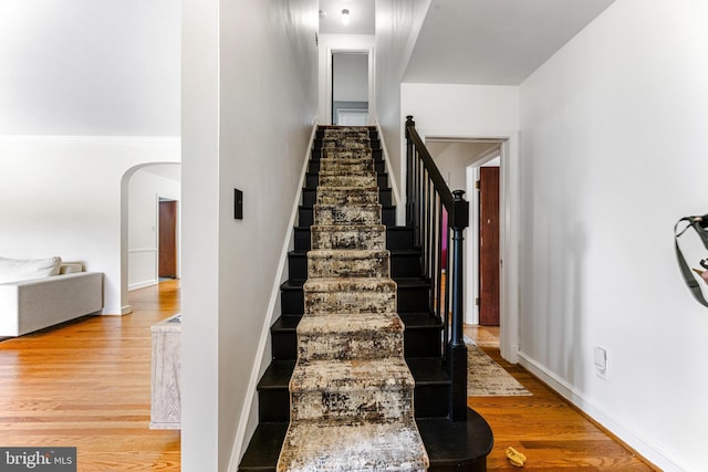 1417 Glendale Rd, Baltimore, MD 21239 - stairway with arched walkways, wood finished floors, and baseboards
