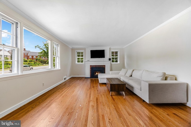 1417 Glendale Rd, Baltimore, MD 21239 - living room featuring crown molding, a brick fireplace, light wood-style floors, and baseboards