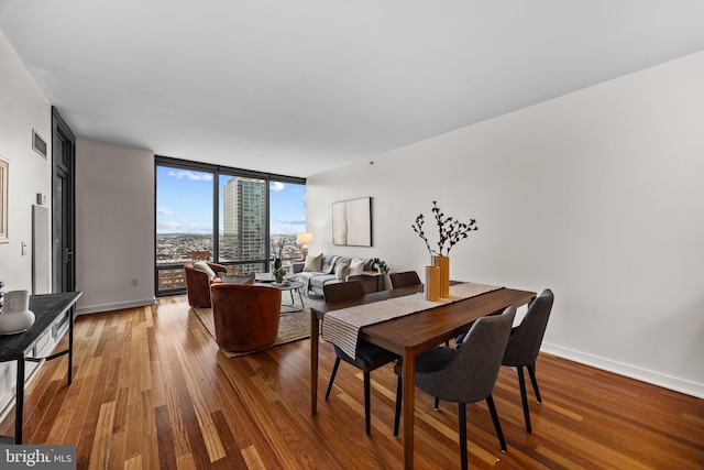 2101 Market St Unit 705, Philadelphia, PA 19103 - dining area featuring baseboards, visible vents, floor to ceiling windows, and wood finished floors