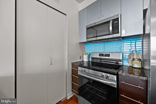 2101 Market St Unit 705, Philadelphia, PA 19103 - kitchen featuring stainless steel appliances, dark stone countertops, decorative backsplash, and dark brown cabinetry